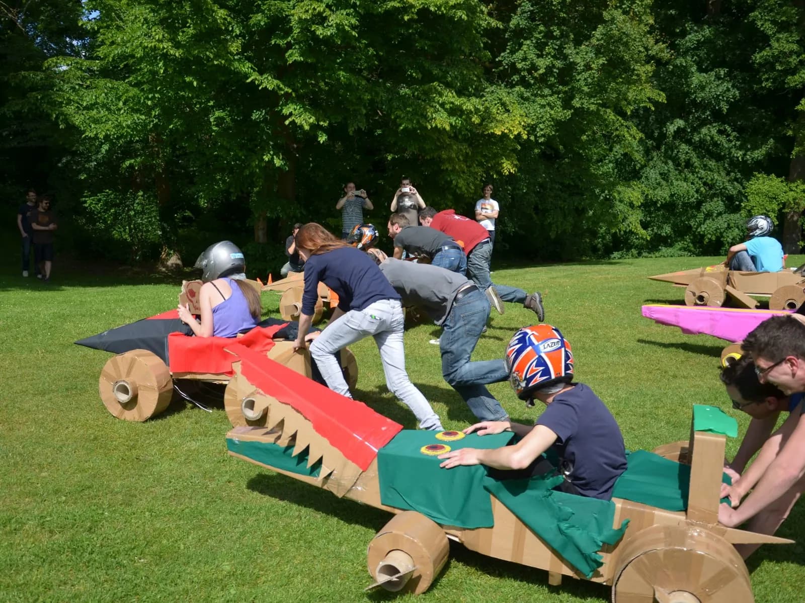 Team building a cardboard car in a park near Paris