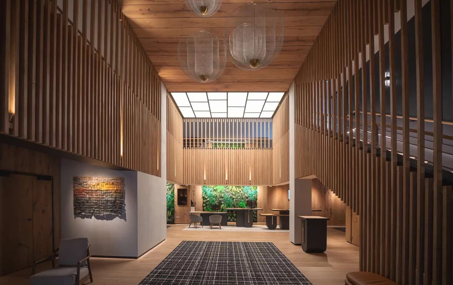 Wood-slatted lobby with a glass skylight, chandeliers and a green wall at Best Western Premier Hôtel de la Paix, Reims