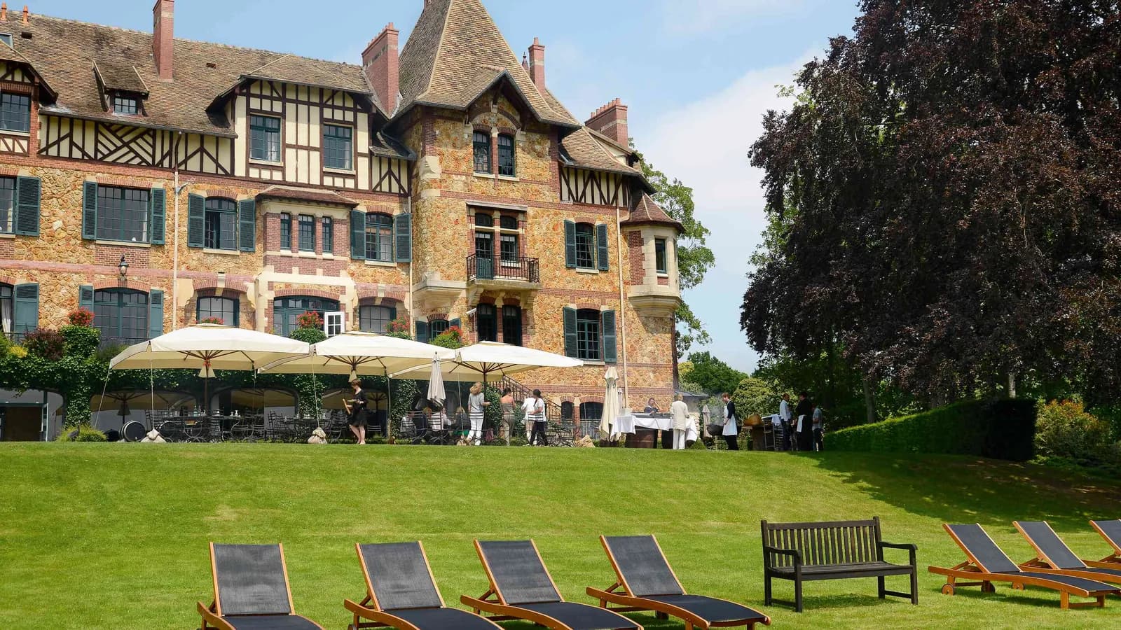 Château à colombages avec pelouse, transats et parasols au Château des Berges Sereines, Yvelines