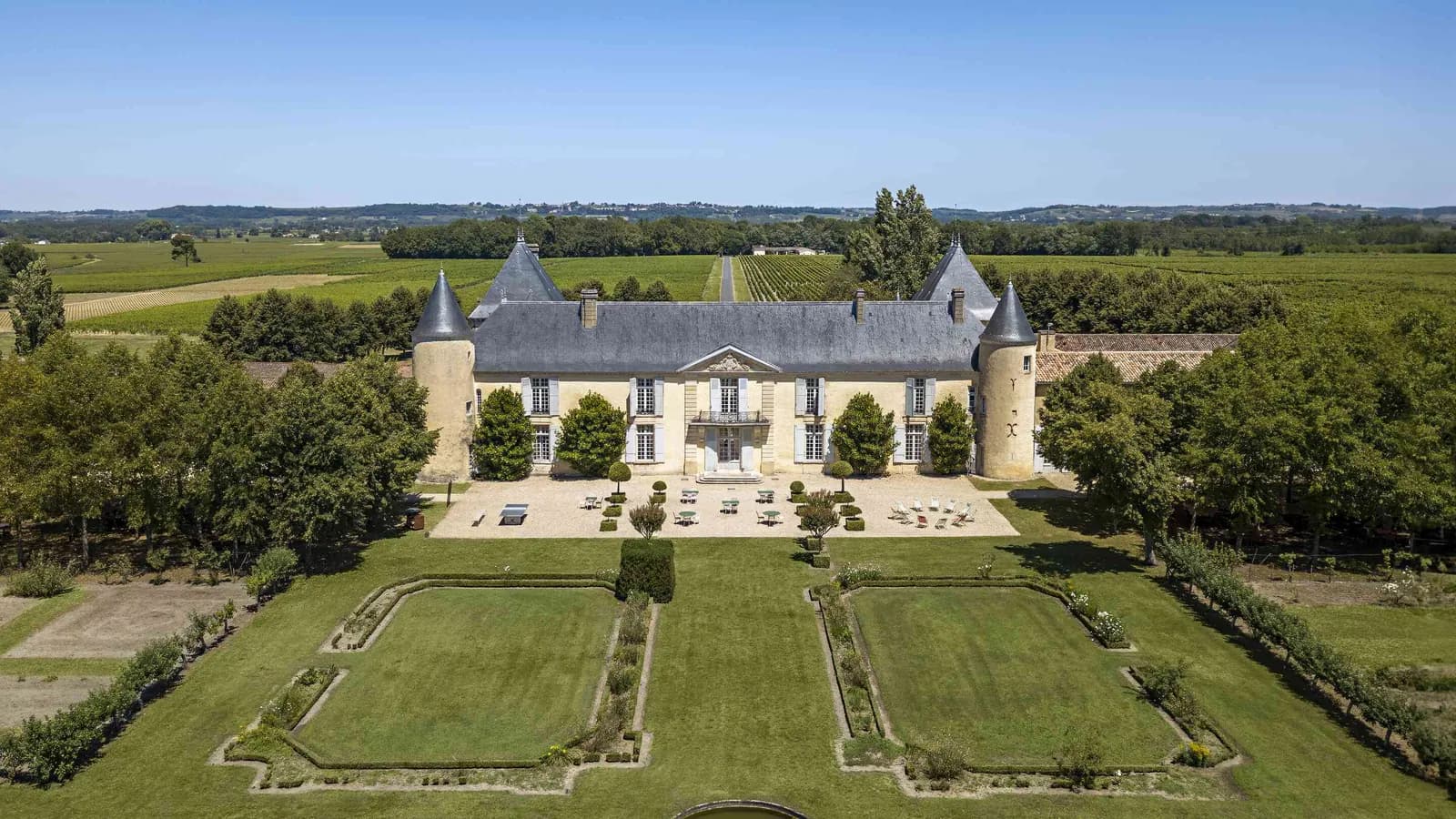 Vue aérienne du château et de ses jardins à la française au Château des Coteaux Ambrés, en Gironde