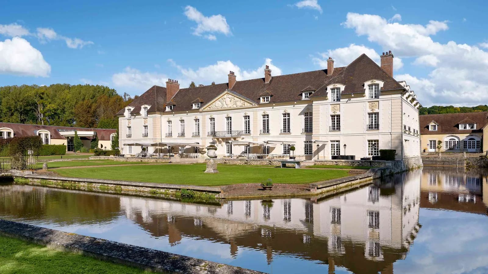 Château reflété dans un long bassin, bois et pelouses au Château des Hauts Tilleuls, au nord de Paris