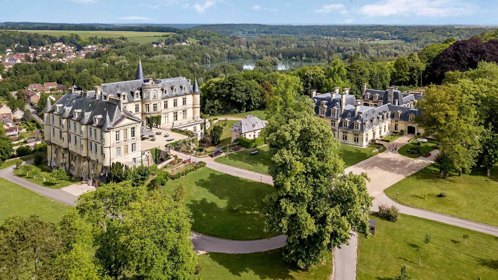 Vue aérienne du Château des Tourelles Blanches, château classique au cœur d'un parc boisé dans l'Oise