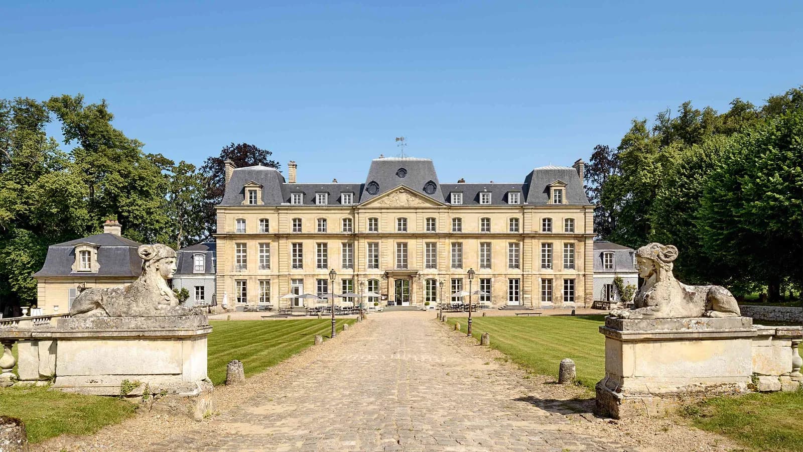 Château avec lions de pierre et allée de gravier vers l'entrée du Château du Val Vert, dans le Val-d'Oise