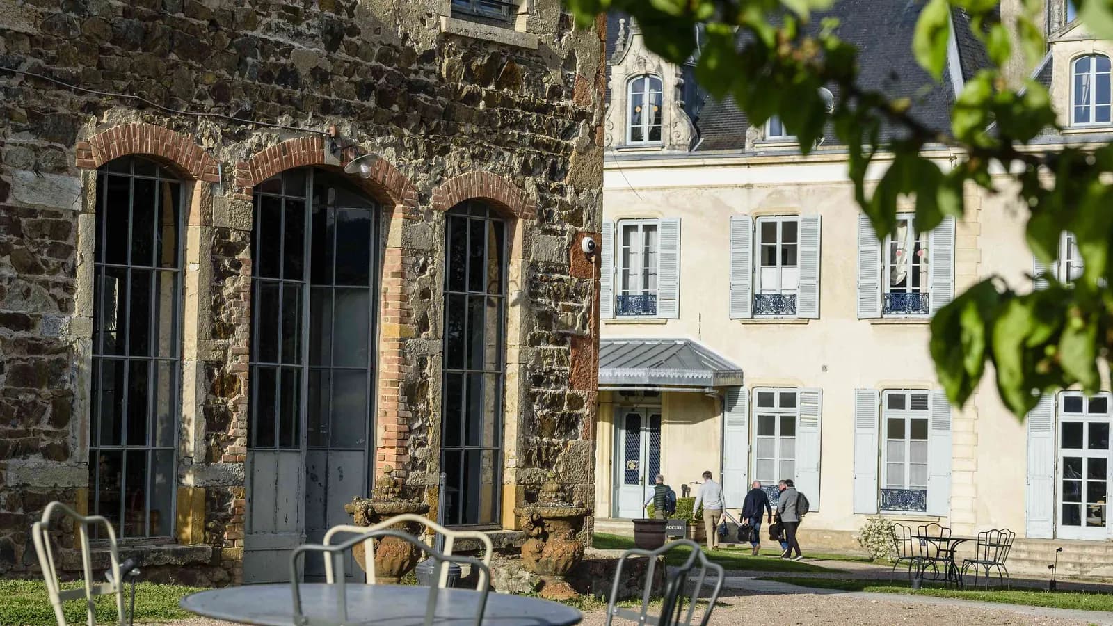 Bâtiment de pierre aux fenêtres cintrées et belle cour en pierre à la Demeure du Haut Beaujolais, Rhône