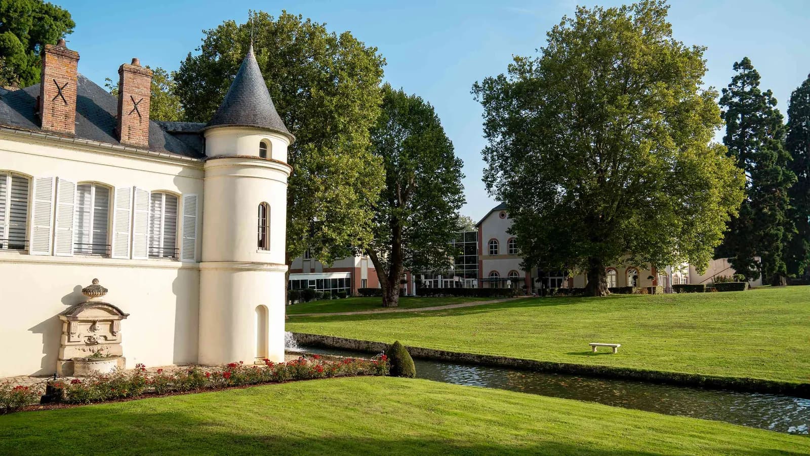Façade du château, pelouse et pièce d'eau au Domaine des Hautes Clairières, Oise, au nord de Paris