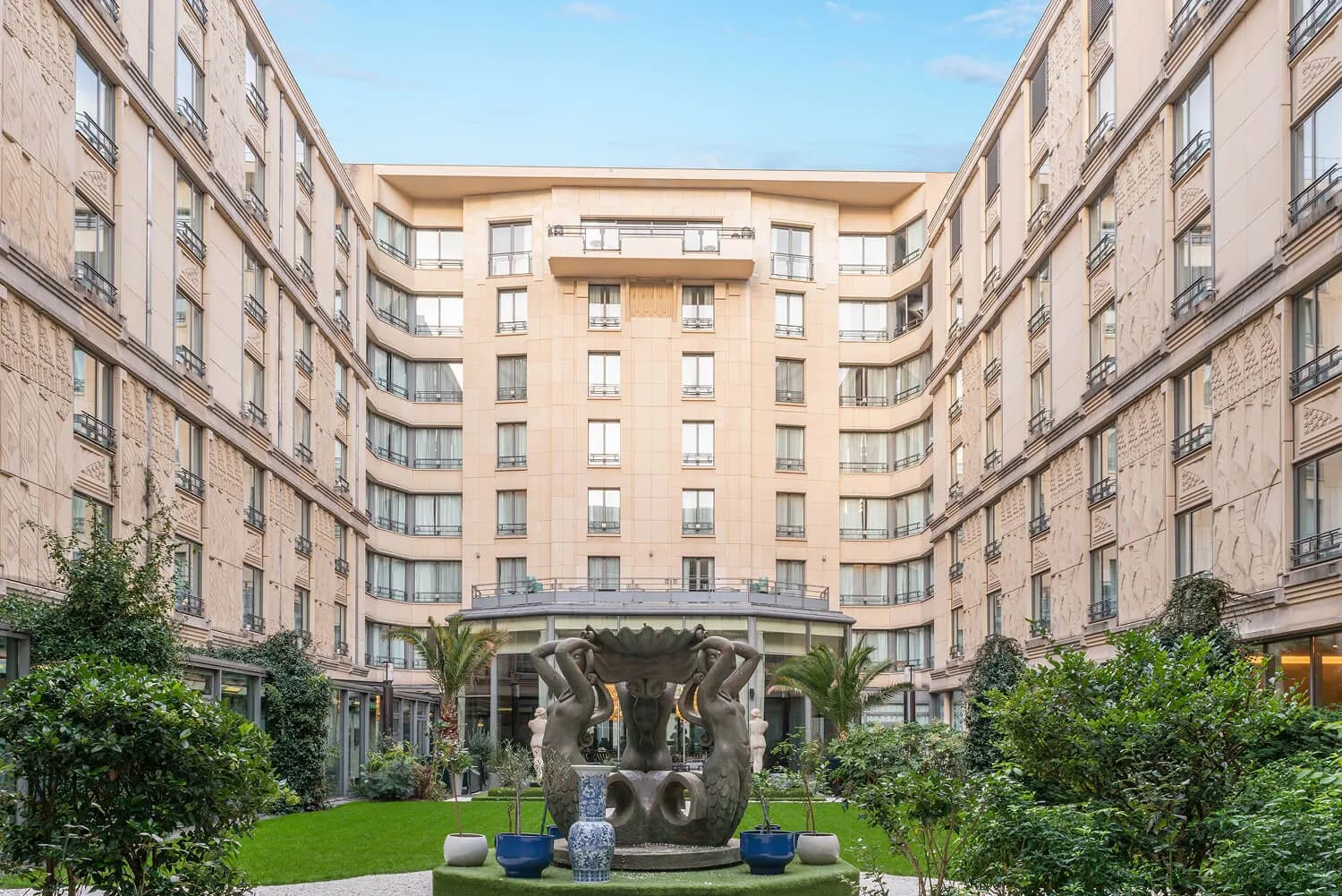 Jardin intérieur et façade en pierre de l'Hôtel du Collectionneur Arc de Triomphe, avec une sculpture en bronze