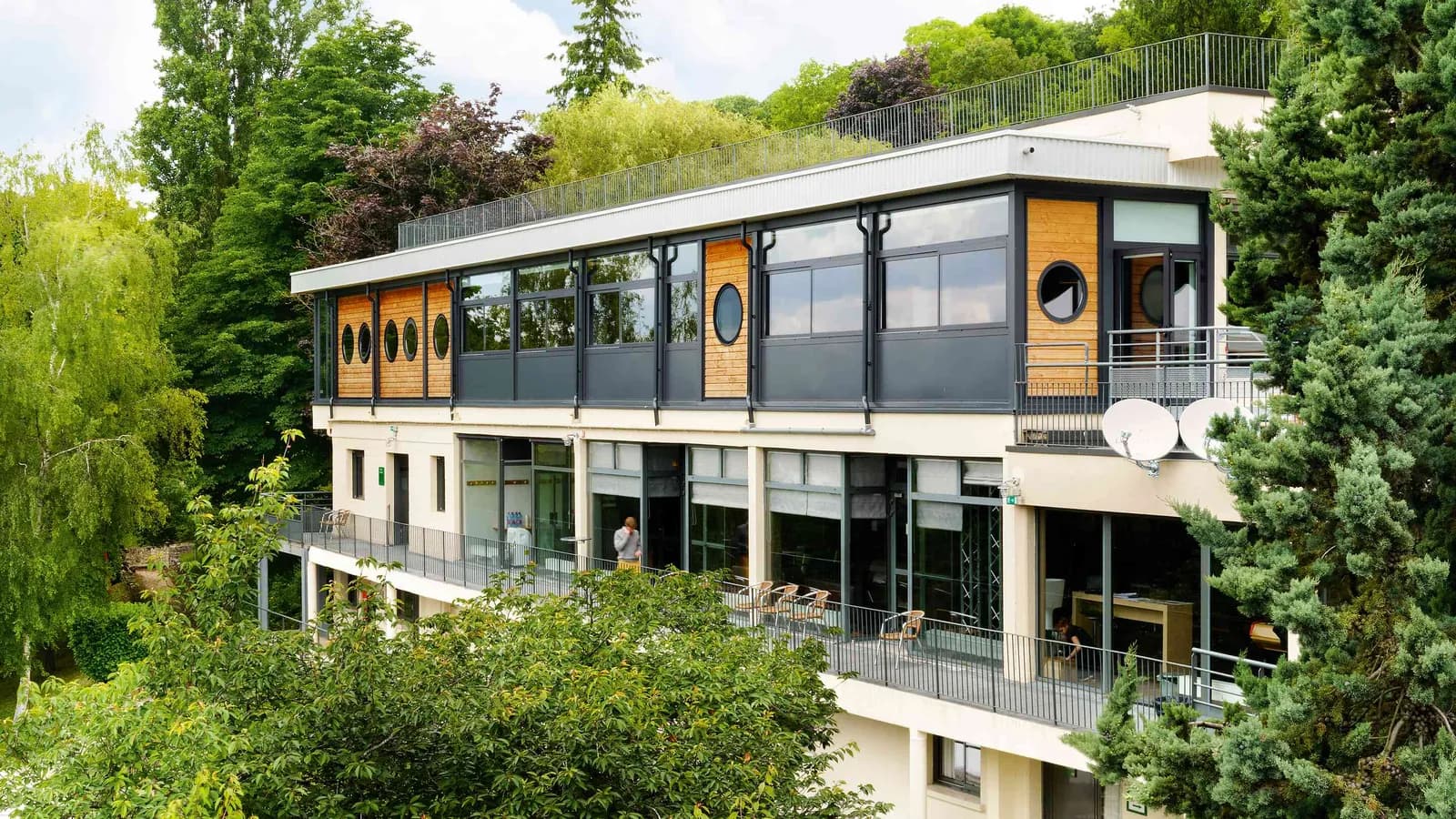 Façade du campus de séminaire Les Jardins du Fleuve en Seine-et-Marne, bâtiment à deux niveaux bordé de grands arbres