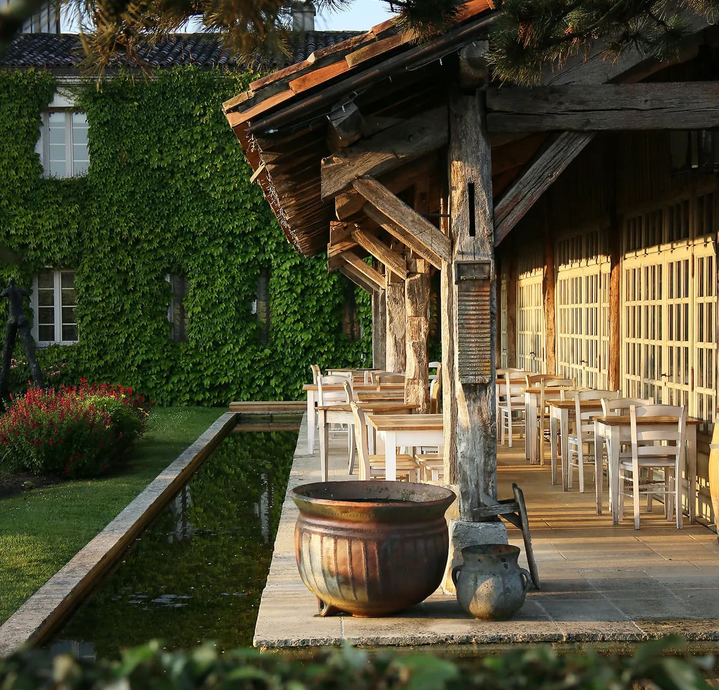 Covered terrace with wooden beams and ivy-clad walls at Les Sources de Caudalie, Martillac near Bordeaux