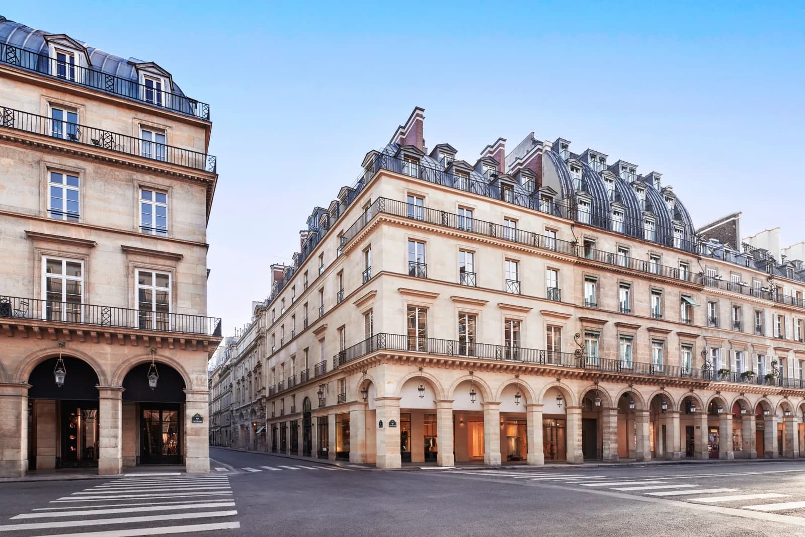 Façade en pierre de la Maison Barrière Vendôme à un angle de rue ensoleillé, arcades et toits mansardés