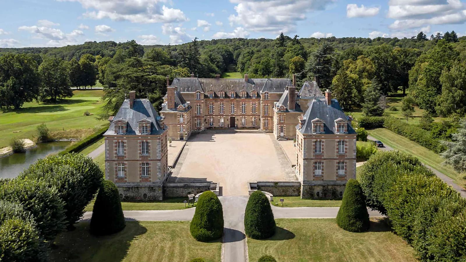 Vue aérienne du manoir, de sa cour et de son parc boisé au Manoir des Prés Fleuris, dans les Yvelines