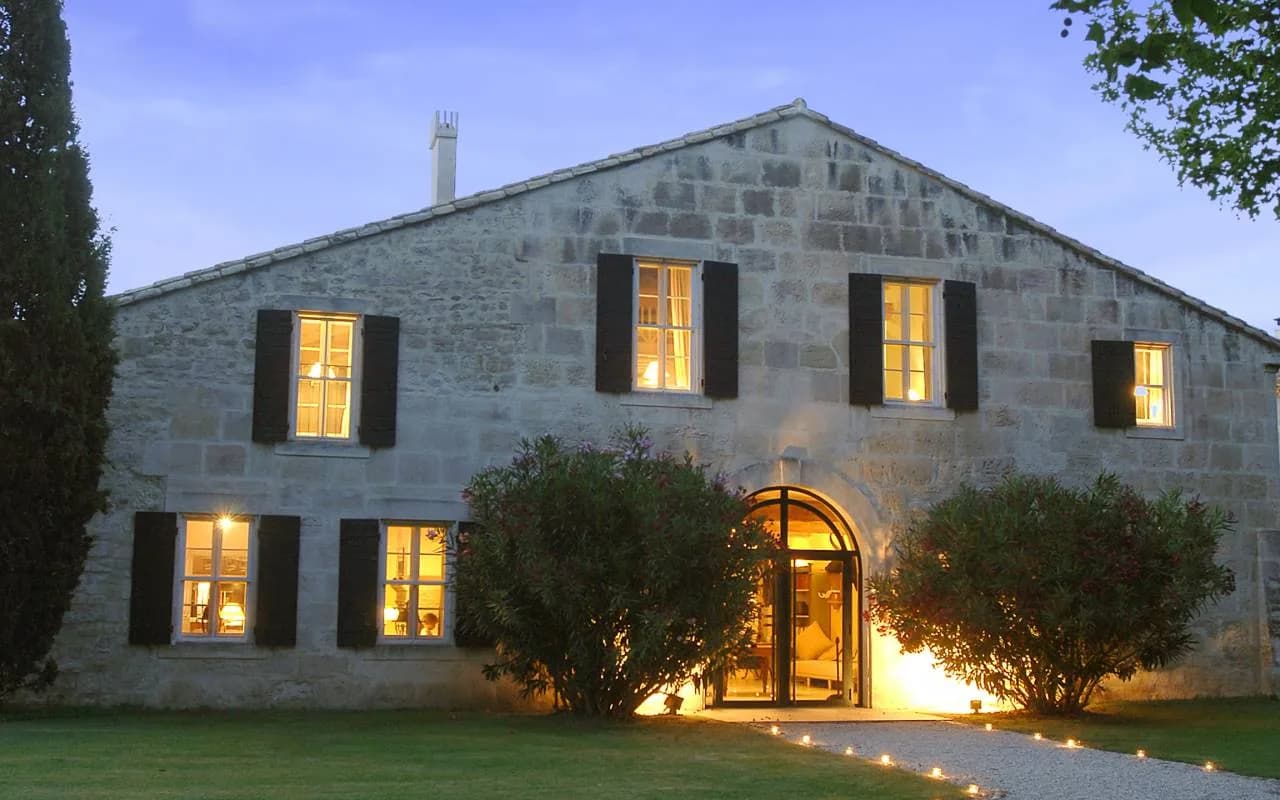 Stone estate house of Mas de Peint lit up at dusk, Le Sambuc, Camargue