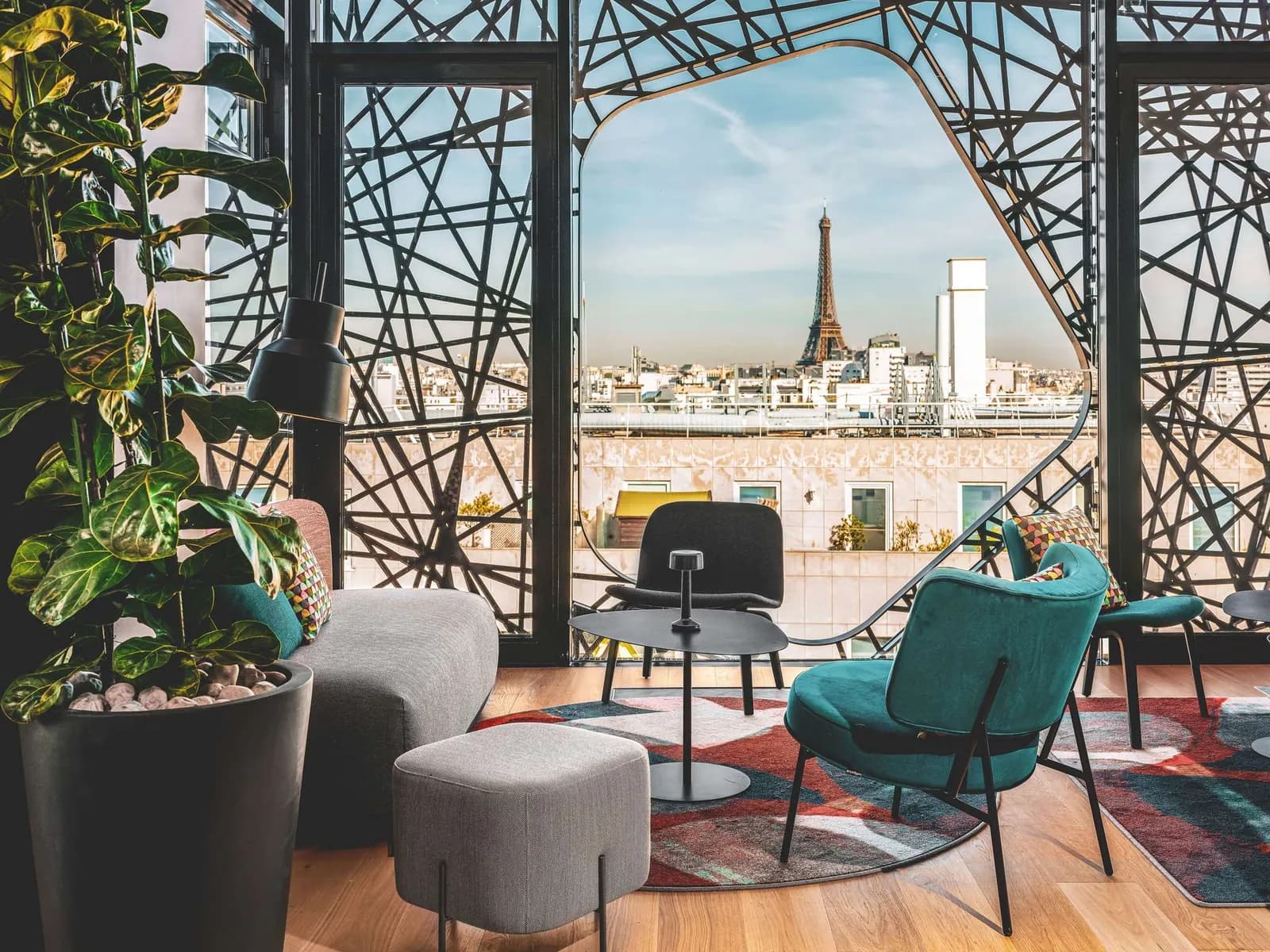 Lounge with a view of the Eiffel Tower through a steel lattice at Novotel Paris Vaugirard Montparnasse