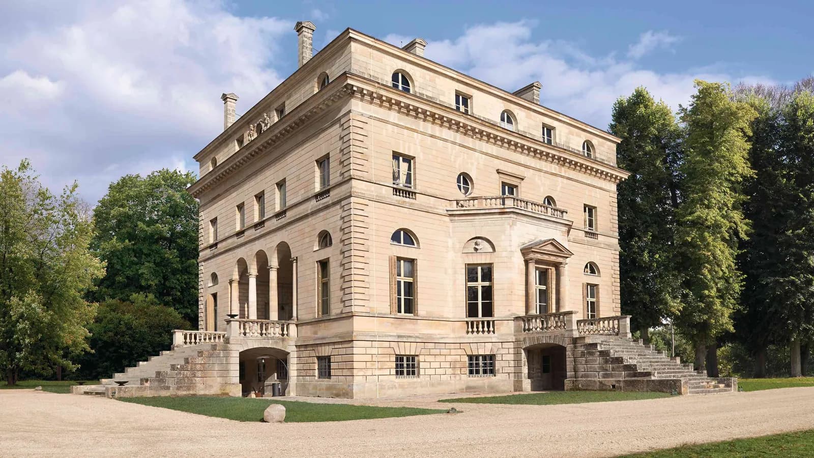 Façade en pierre du palais, grand escalier et parc arboré au Palais des Bords d'Oise, Val-d'Oise