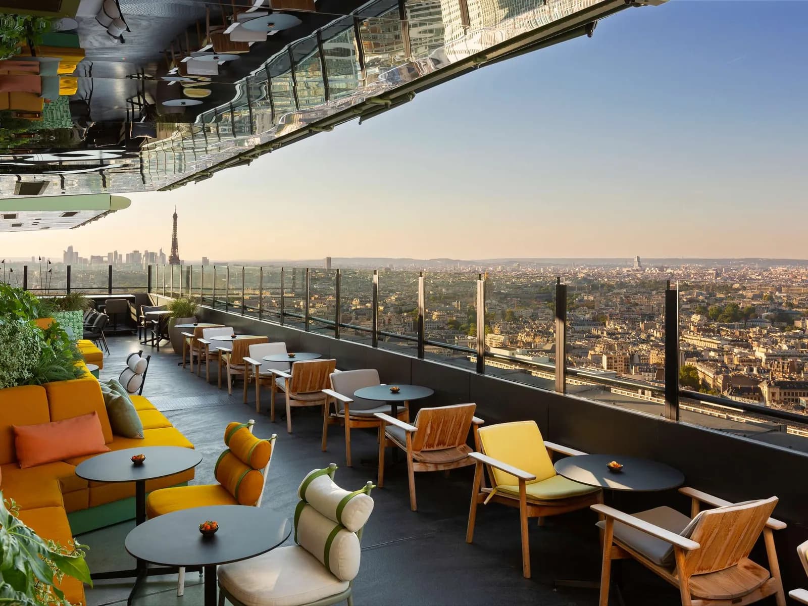 Rooftop terrace with yellow sofas and a view of the Paris skyline at Pullman Paris Montparnasse