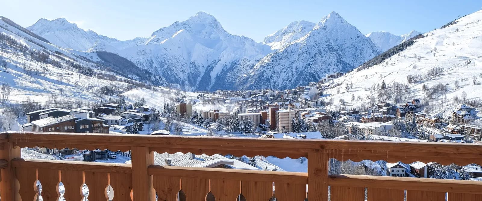 Balcony view over snowy Alpine rooftops and peaks at Résidence des Cimes Blanches, French Alps