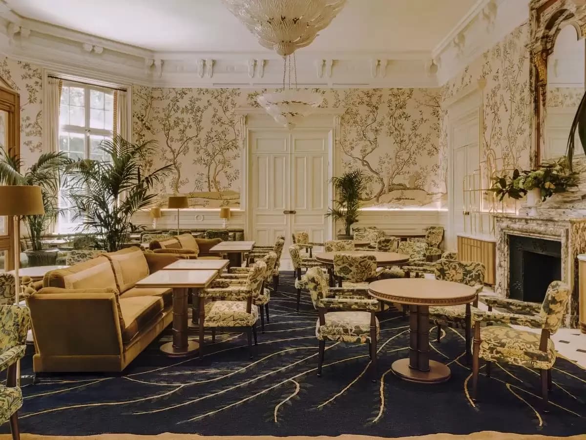 Lounge with floral wallpaper, velvet armchairs and a fireplace at Saint James Paris, Paris 16e