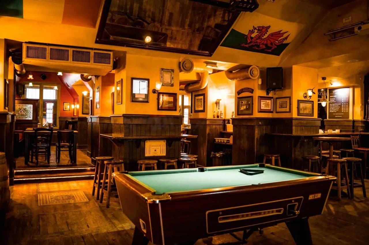 Pub room with a pool table and a wooden bar