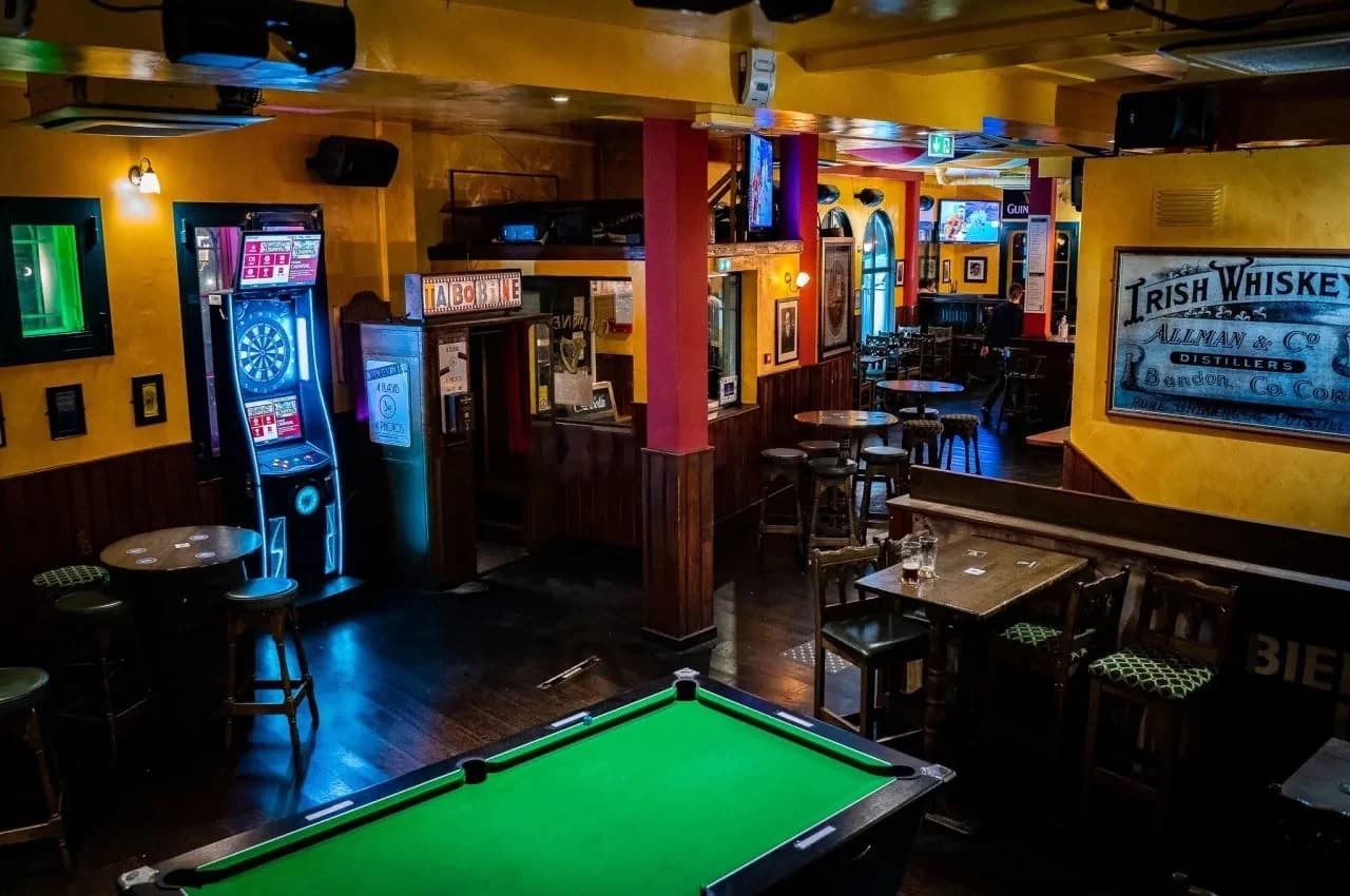 Pub room with a green pool table and a dartboard