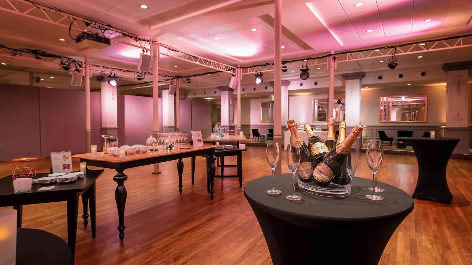 Mise en place cocktail au Grand Hall Étoile avec tables hautes, champagne et éclairage rose