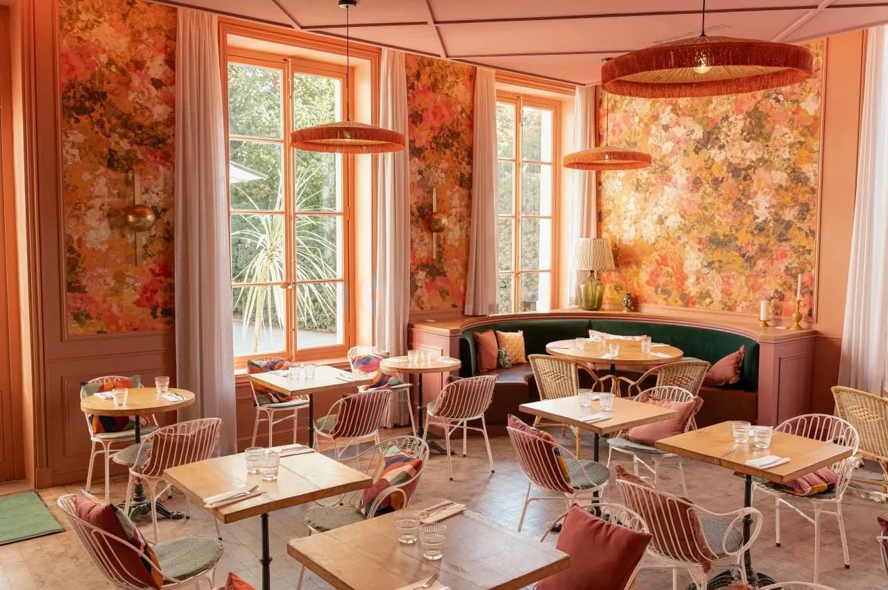 Restaurant room with pink floral walls and banquette seating