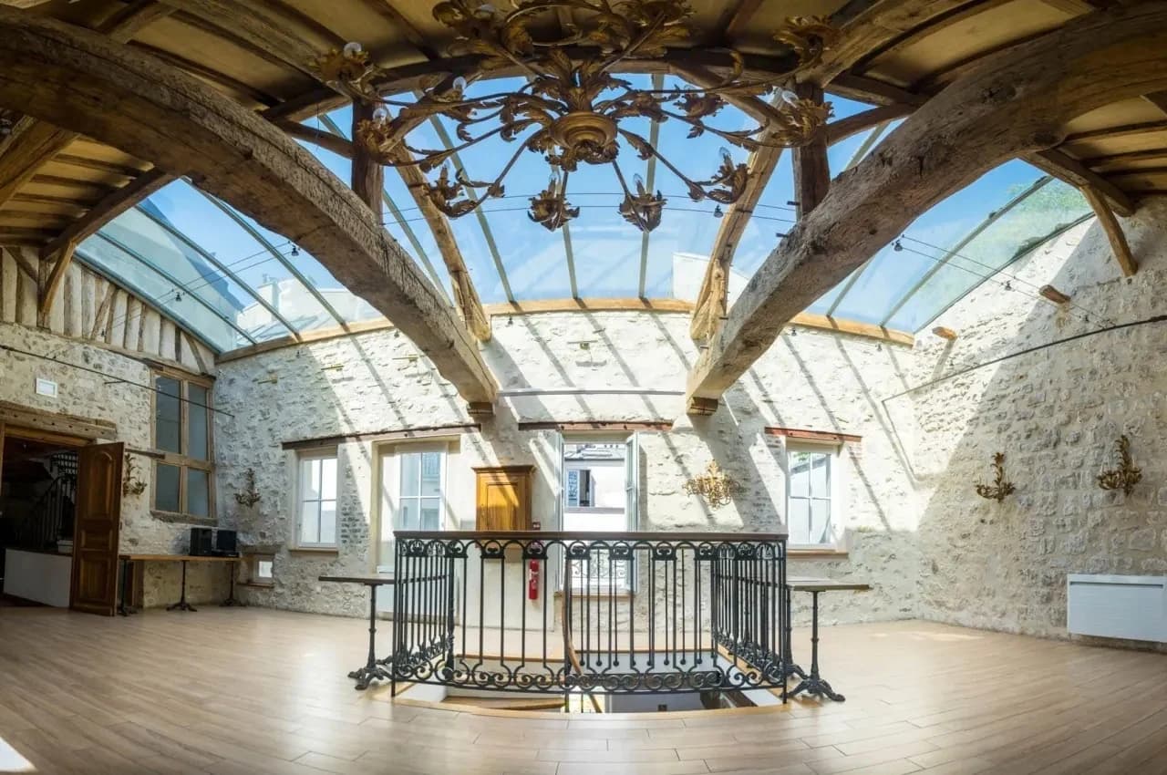 Historic room with exposed beams, a glass roof and a metal balustrade