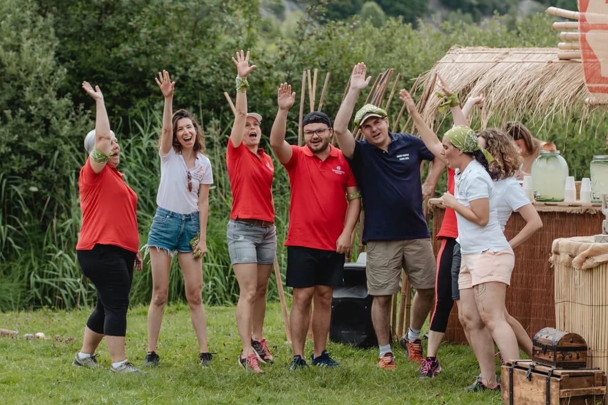 Membres d'une équipe qui célèbrent ensemble en plein air pendant un défi de groupe