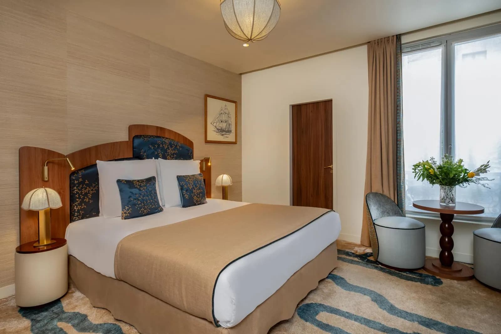 Guest room at Hôtel La Bourdonnais Paris with a walnut headboard and blue silk cushions, near the Eiffel Tower