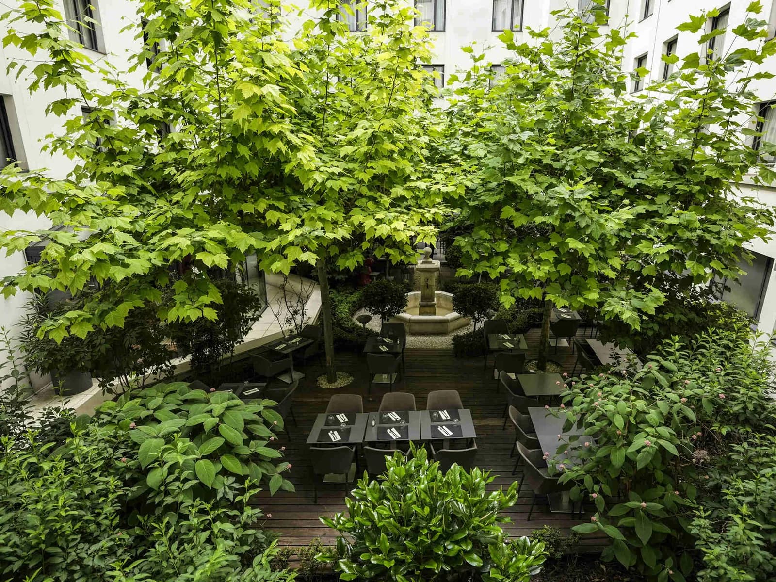 Shaded garden terrace with bistro tables at Mercure Paris Gare Montparnasse TGV, Paris