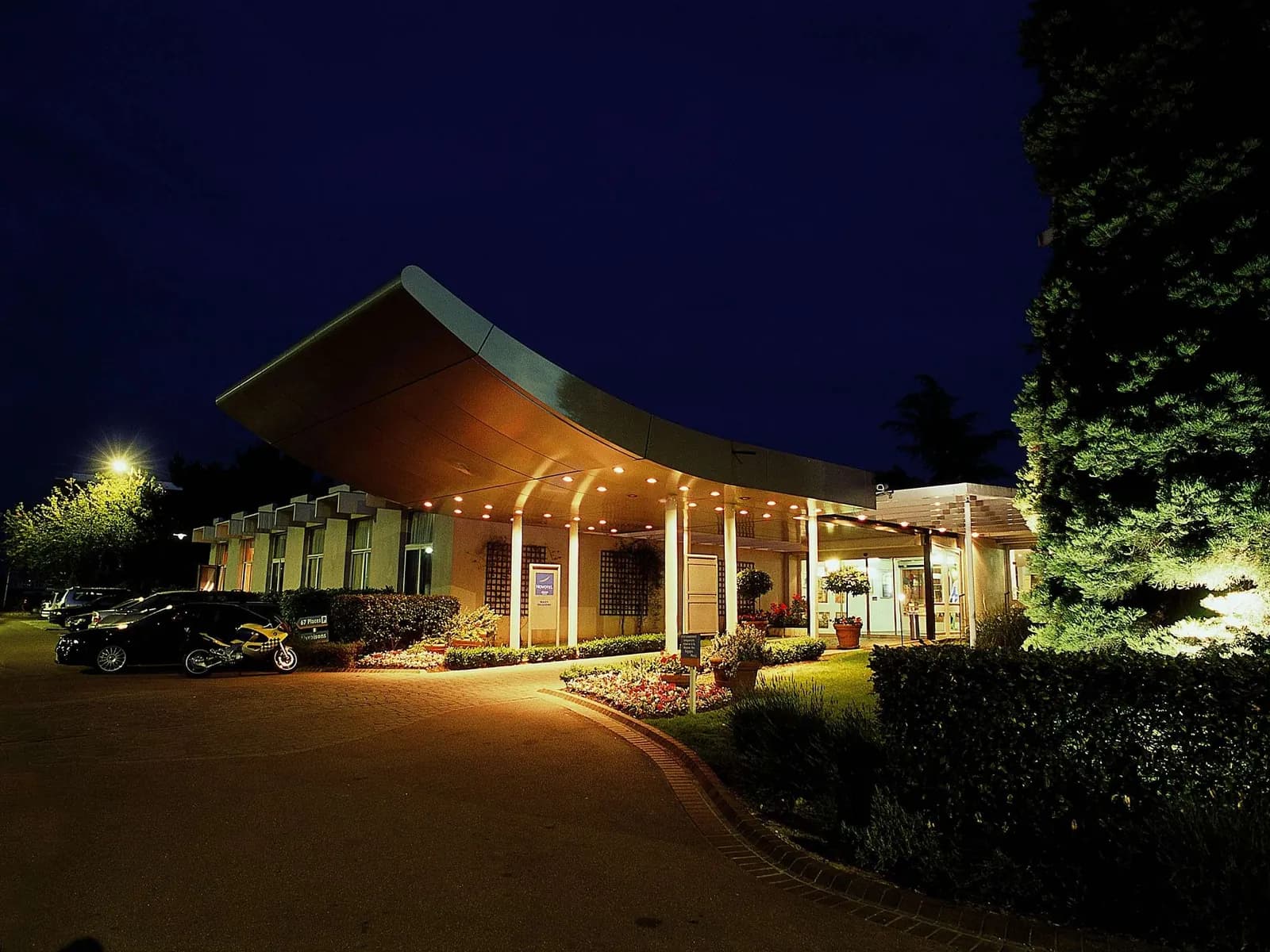 Evening view of the entrance and covered drive of Novotel Massy Palaiseau, Palaiseau