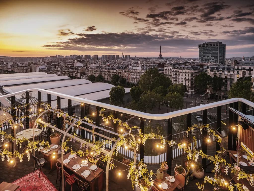 Rooftop terrace at dusk with string lights and Paris skyline and Eiffel Tower at Novotel Paris Porte de Versailles