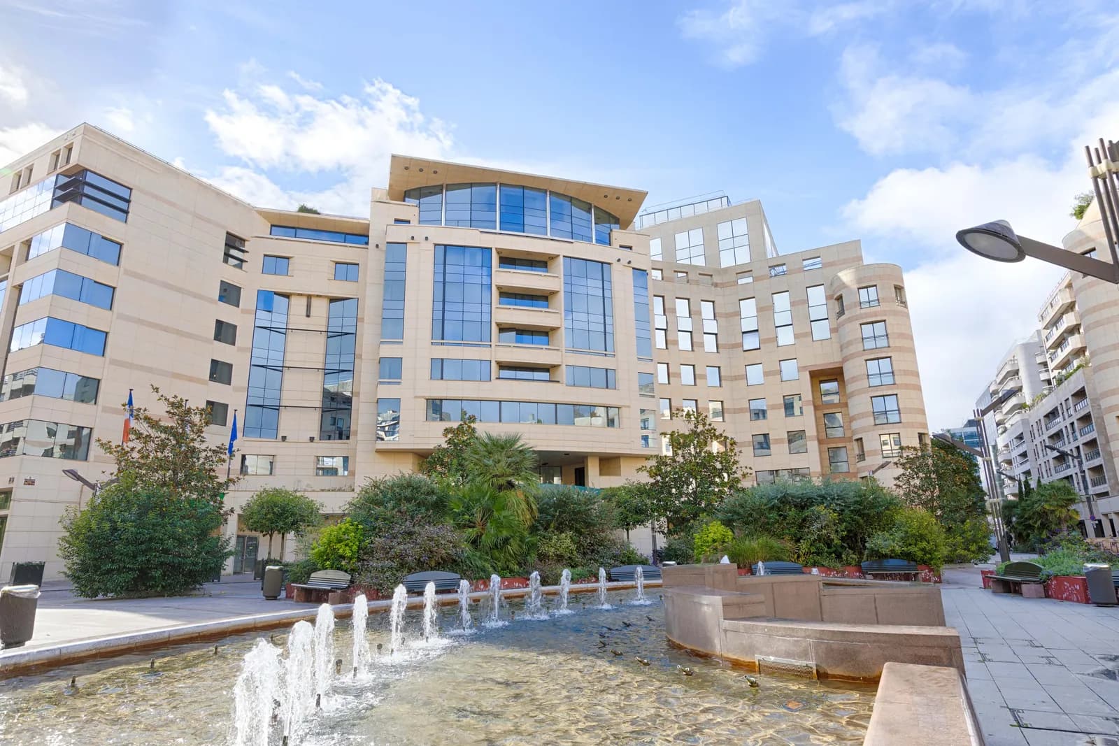 Courtyard with fountain and tiered facade of Occidental Paris Levallois hotel in Levallois-Perret