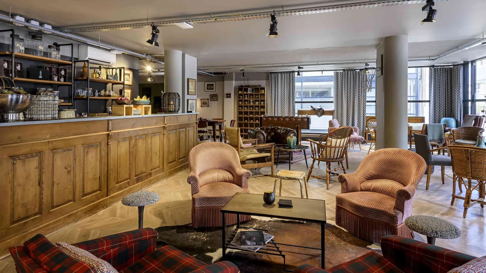 Bar salon de la Maison des Ateliers avec fauteuils en cuir, comptoir en bois et lampes vintage