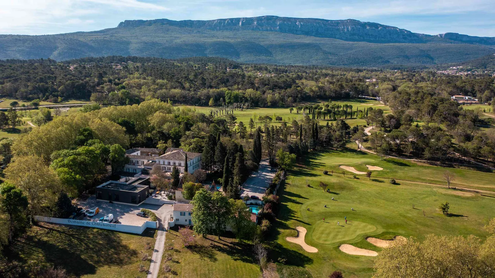 Vue aérienne de la Bastide des Collines Dorées avec son parcours de golf, sa piscine et la crête au loin