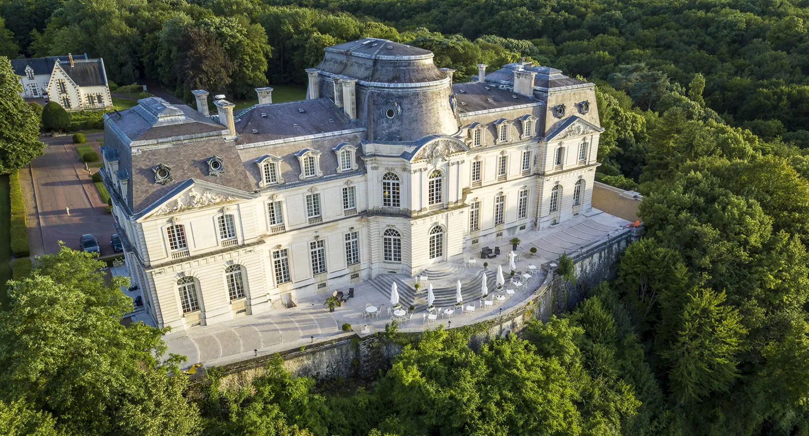 Aerial view of the Château d'Artigny hotel surrounded by woodland in Montbazon, Loire Valley