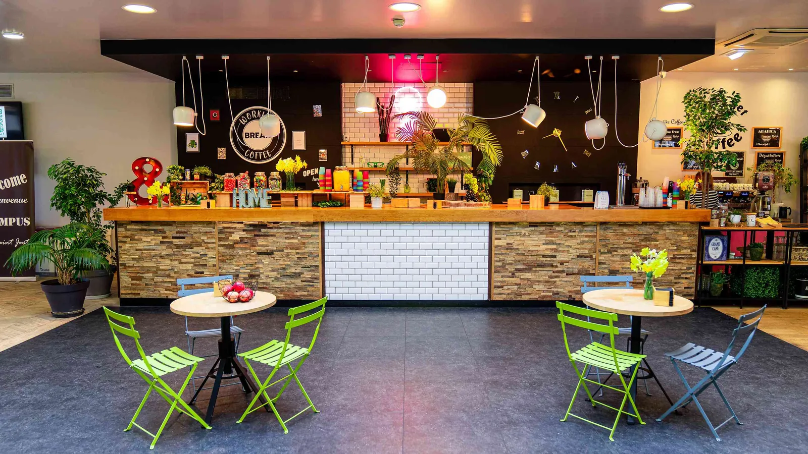 Bar lounge with high tables and bright green chairs at Domaine des Hautes Clairières, Oise