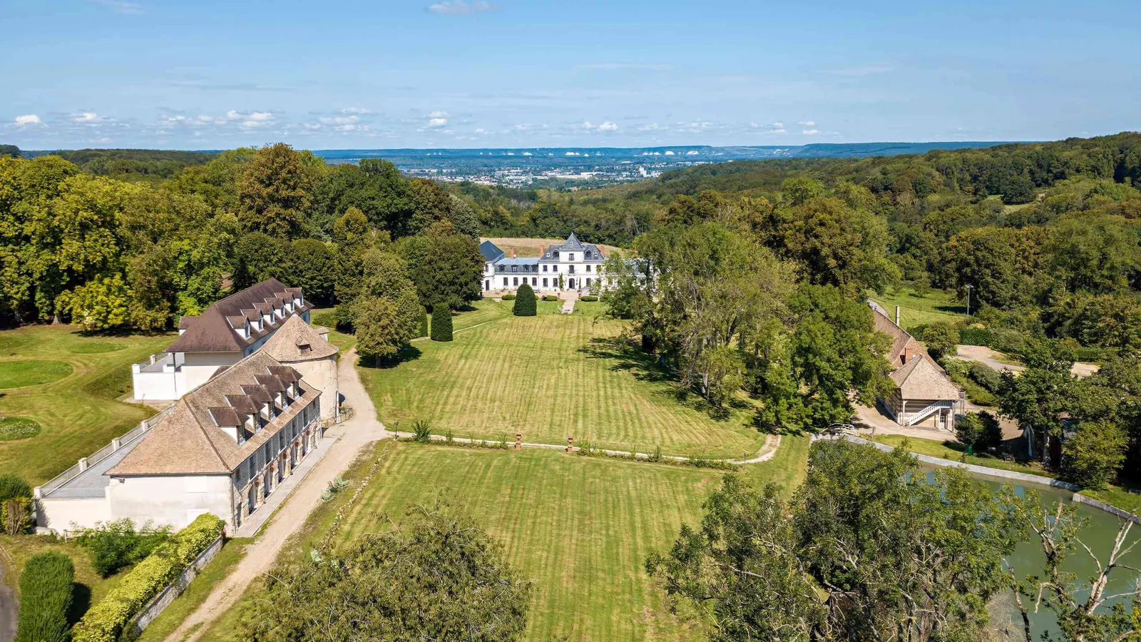 Aerial view of Domaine des Hêtres Clairs with its château, lawns, orchard and pond in Eure