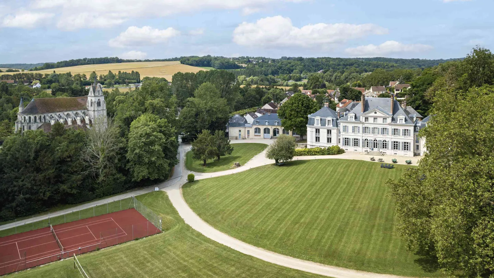Vue aérienne du Domaine des Ormes Blancs, avec son château, son parc boisé et son court de tennis
