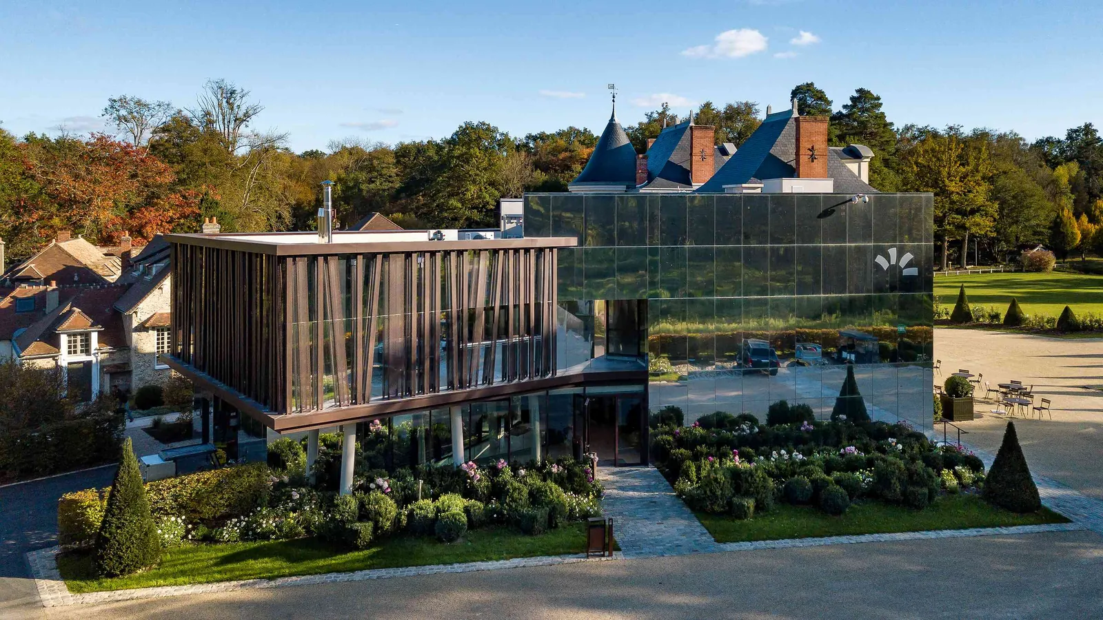 Glass-fronted learning building beside the château at Domaine des Sources Vertes, Yvelines