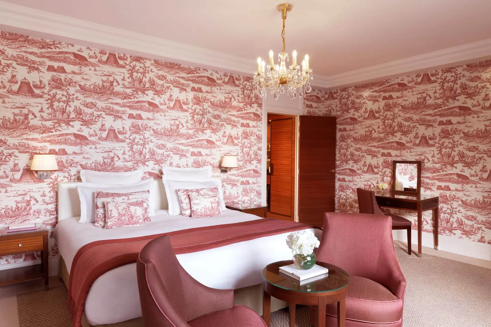 Prestige bedroom with red toile de Jouy wallpaper and a crystal chandelier at Hôtel Barrière Le Normandy, Deauville