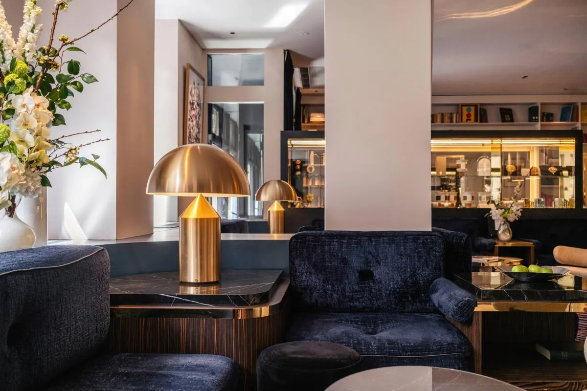 Lobby lounge at Hôtel Bel Ami Paris with navy velvet sofas and brass table lamps in the 6th arrondissement