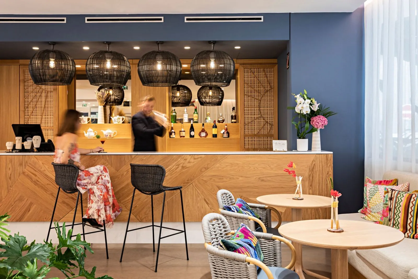 Lobby bar with wooden counter, pendant lamps and bar stools at Hôtel Croisette Beach Cannes MGallery