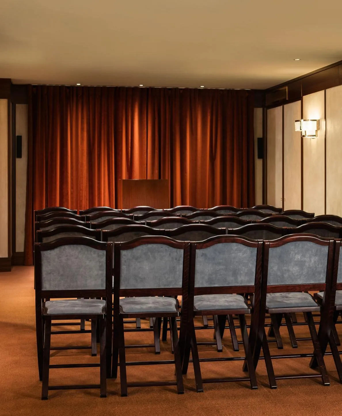 Theatre-style seating in a meeting room of Hôtel des Grands Voyageurs, rows of upholstered chairs facing a screen