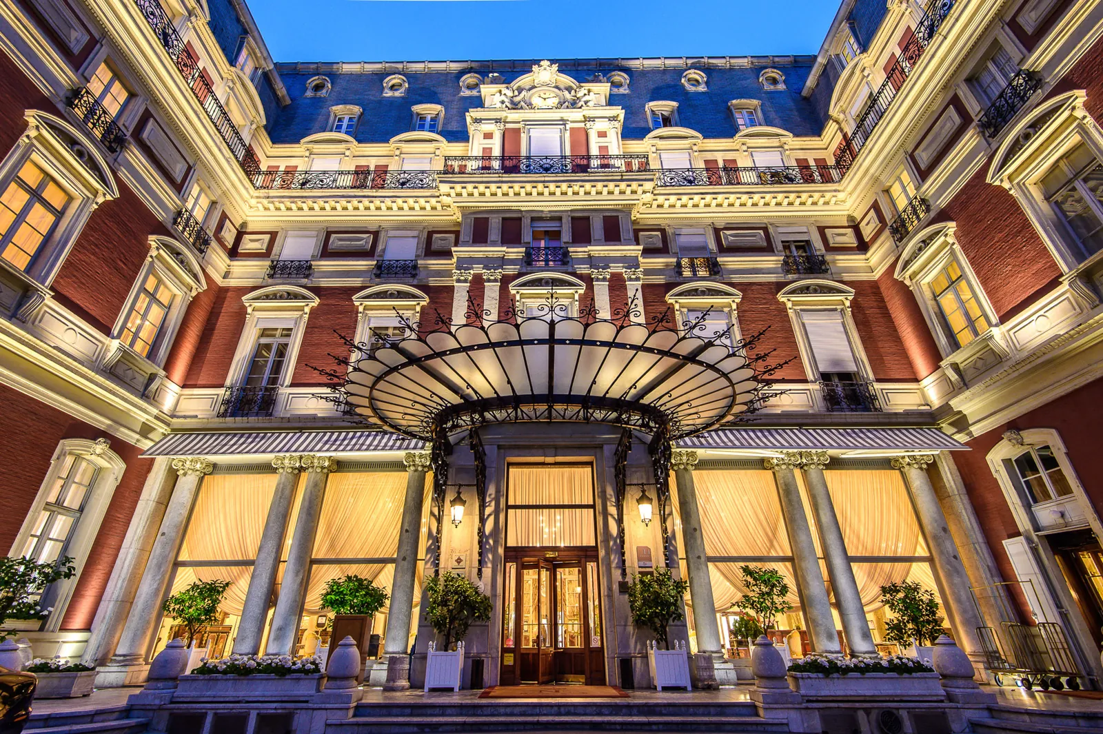 Illuminated entrance courtyard and grand facade of Hôtel du Palais, Biarritz, at night