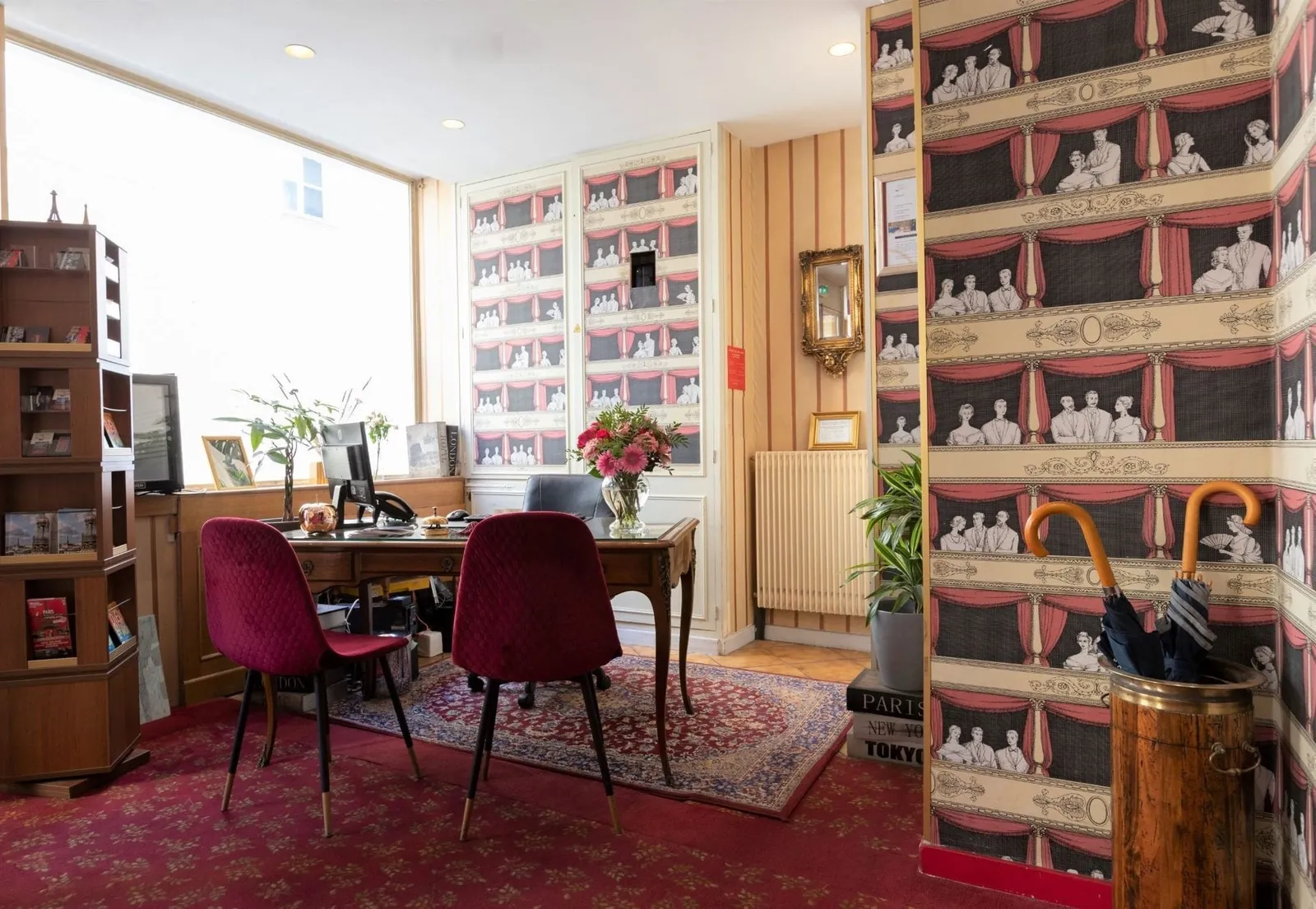 Coin réception et salon de l'Hôtel du Théâtre, papier peint à motifs de théâtre, bureau et fauteuils