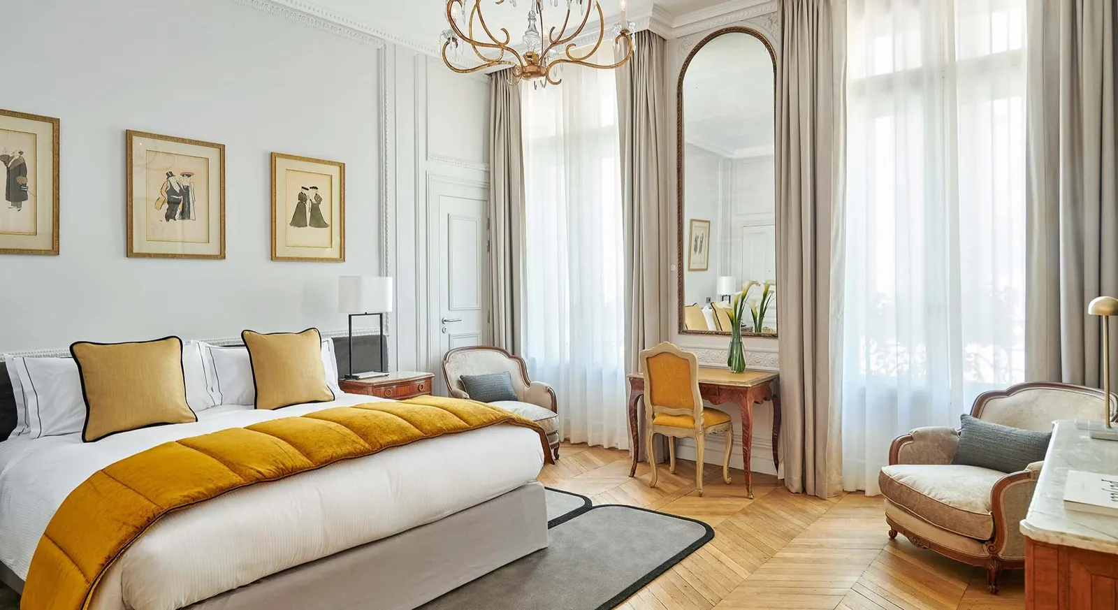 Classic guest room with yellow bedding, tall windows and a gilt mirror at Hôtel Lancaster Paris