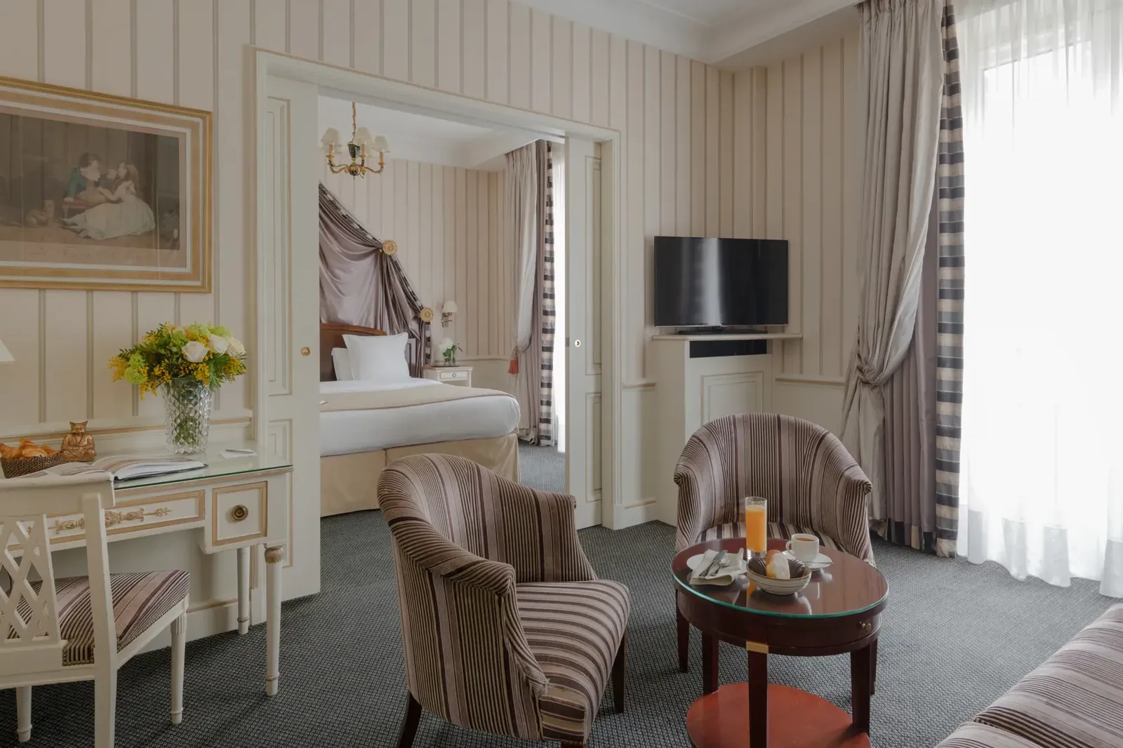 Classic guest room with striped walls, a writing desk and armchairs at Hôtel Napoléon, Paris 8e