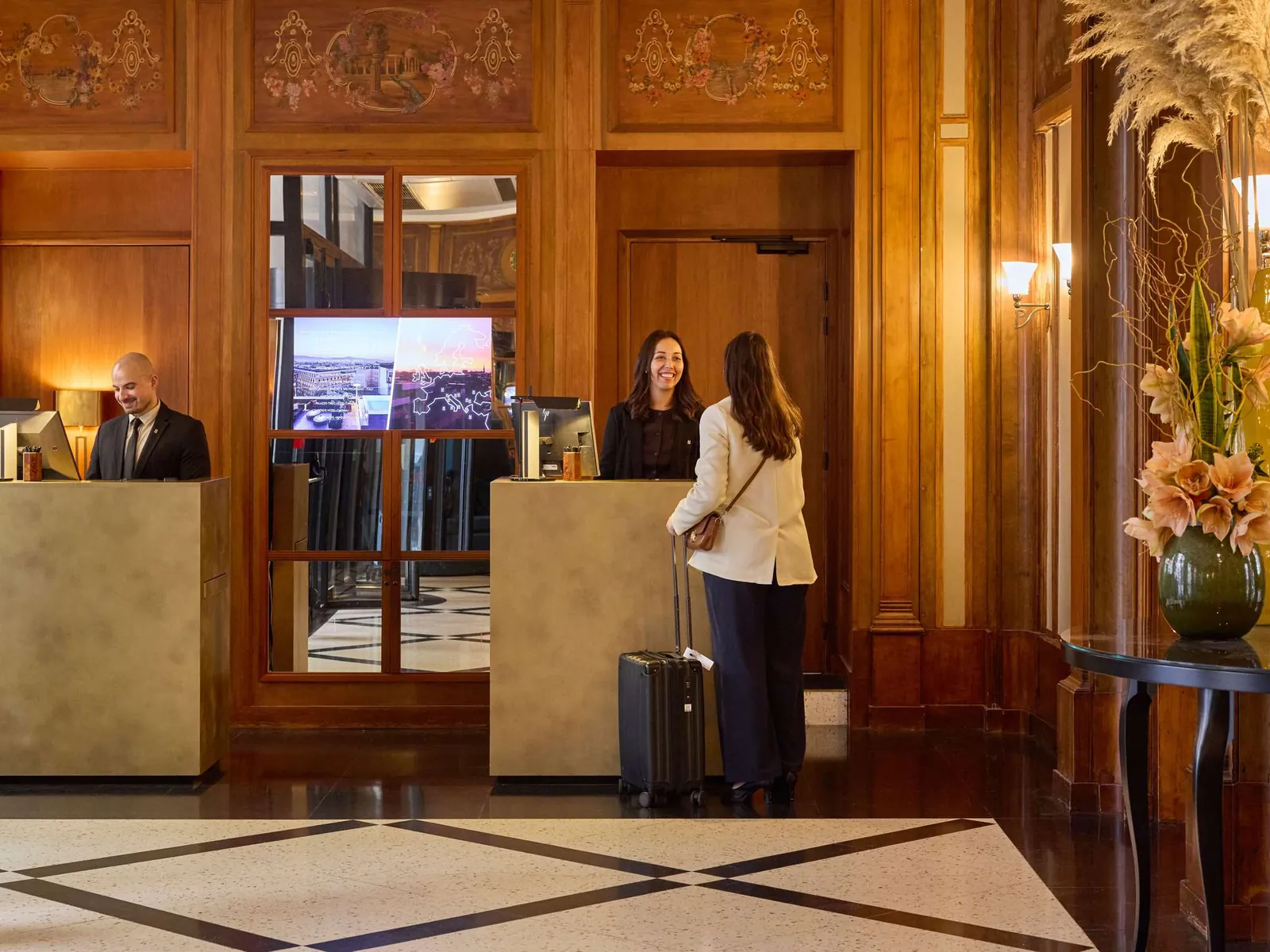 Réception du hall avec boiseries, sol en marbre et client en cours d'enregistrement à L'Echiquier Opéra Paris MGallery