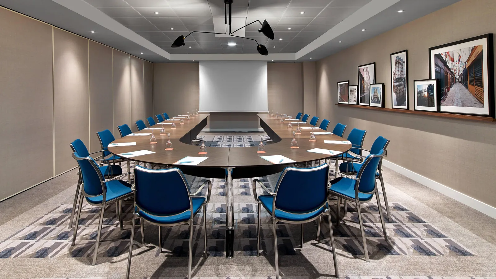 Boardroom set with a U-shaped table and blue chairs at Le Méridien Étoile, Paris