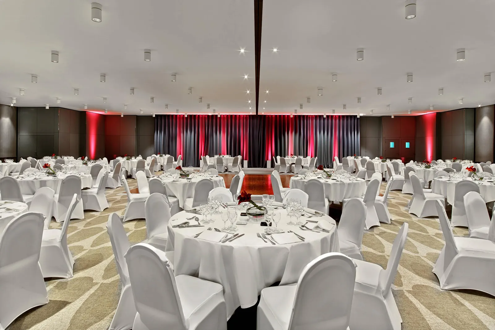Banquet hall with round tables set with white linens for a seated dinner at Le Méridien Étoile, Paris