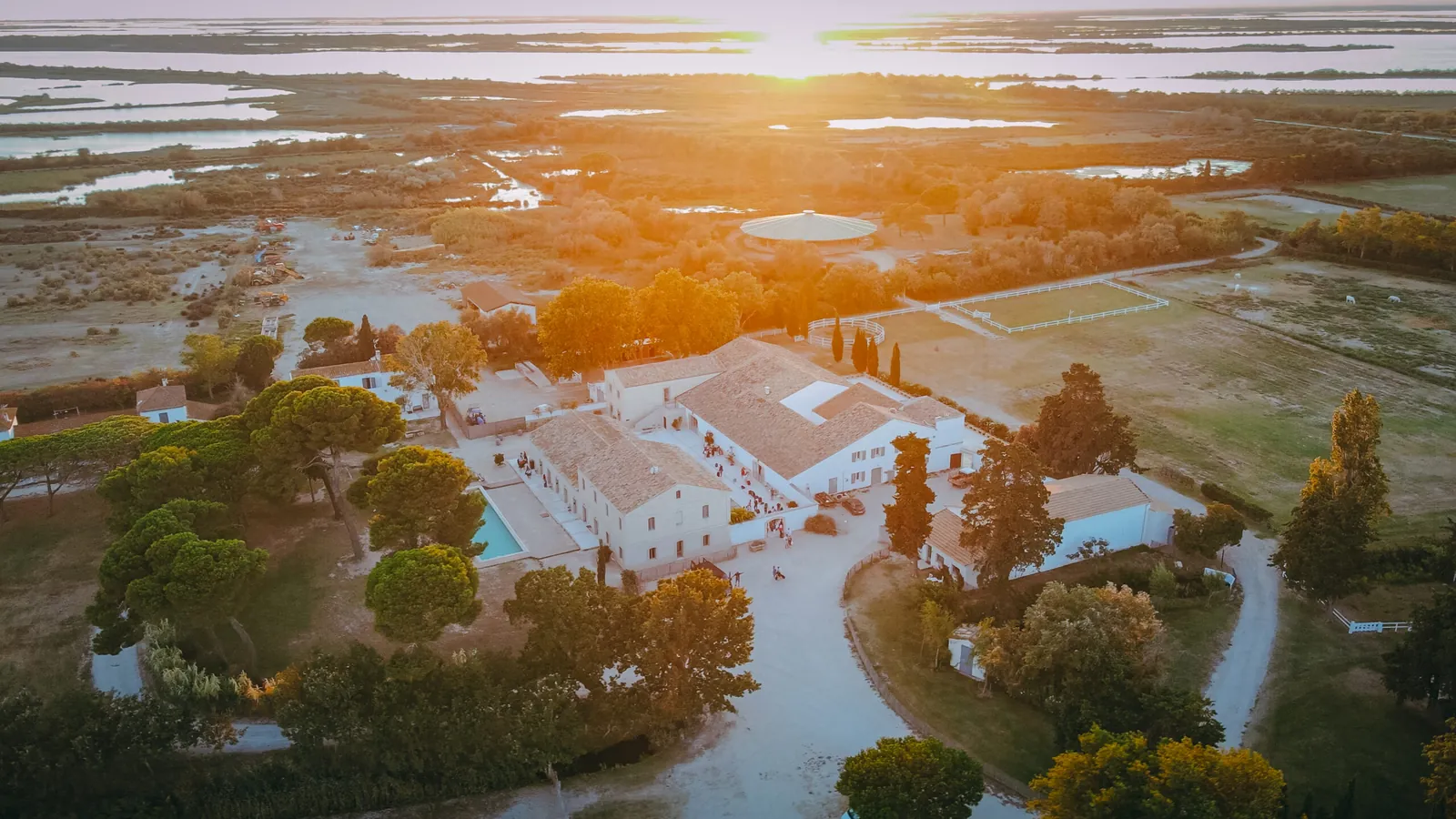 Sunset aerial view of the Domaine Le Sauvage buildings and the lagoons of the Camargue